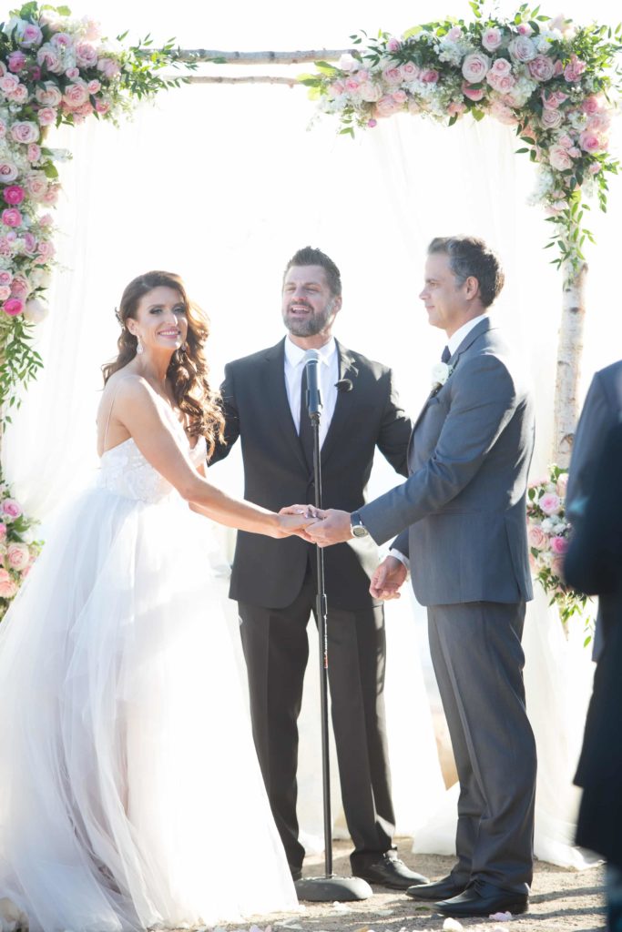 Dana and Grant exchanging vows in wedding organized by Orange County Beach Weddings