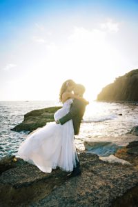 Photo of bride and groom on the rocks at the Ocean Institute. Wedding by Orange County Beach Weddings.