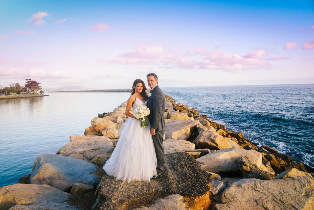 Photo of bride and groom on the rocks at the Ocean Institute. Wedding by Orange County Beach Weddings.