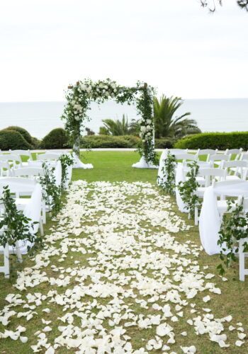 Pines Park in Dana Point wedding ceremony. Arch covered with greens lots of petals down the aisle.